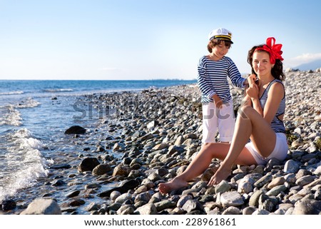 Mom and son walking on the shore of the Greek sea summer day