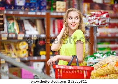 Beautiful young girl with red food baskets merchandised at the grocery store