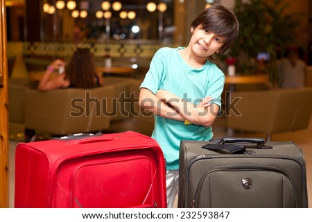 Boy with big suitcases standing in the room before you travel
