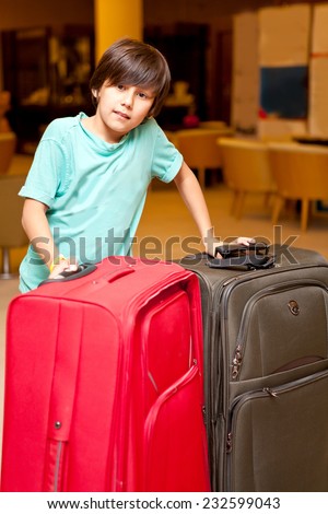 Boy with big suitcases standing in the room before you travel