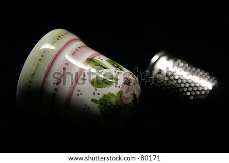 Two thimbles: one of porcelain and one of chromium metal