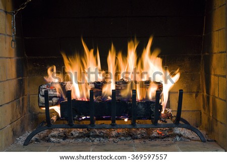 Fire in fireplace. Closeup of firewood burning in fire. Fireplace in the house. Firewood burns in a fireplace. A fireplace in a country house