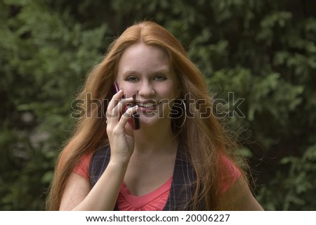 Beautiful red head talking on the phone with the wind in her hair