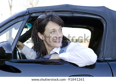 Pretty woman looking behind her as she backs up her car