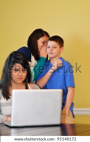 two young siblings talking behind an older students back