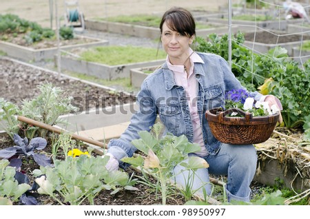 woman working in her garden with a basket of flowers