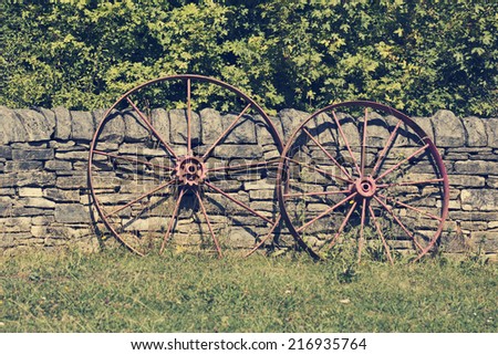 Old wheel against stone fence