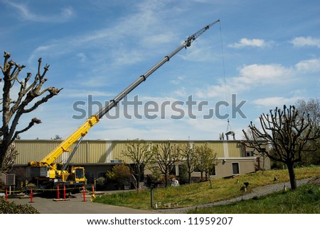 Mobile Crane delivering materials to rooftop