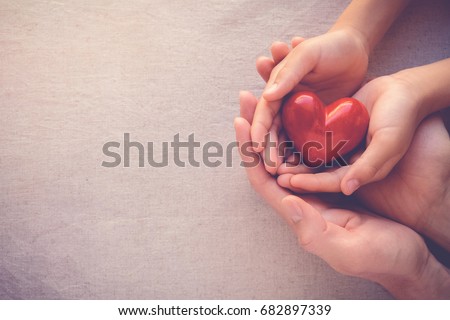 adult and child hands holding red heart, health care, love, hope and family concept