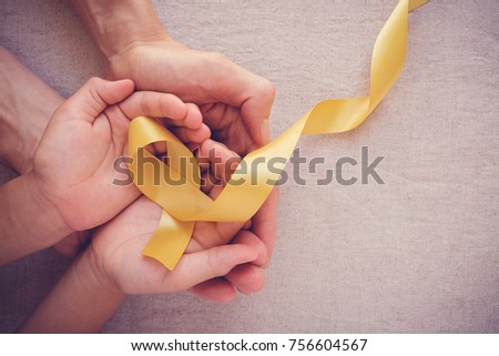 adult and child hands holding yellow gold ribbon, Sarcoma Awareness, Bone cancer, childhood cancer awareness
