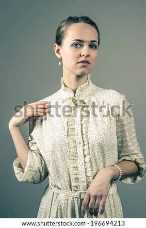 Portrait of a young, attractive girl in vintage dress, with pearl earring