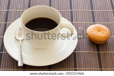Black coffee in white cup and bakery on wooden