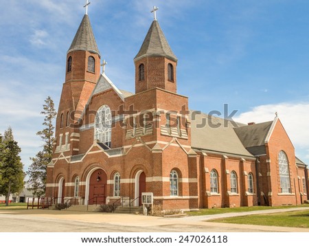 Brick Catholic church with three crosses located in a small town in the Midwestern United States