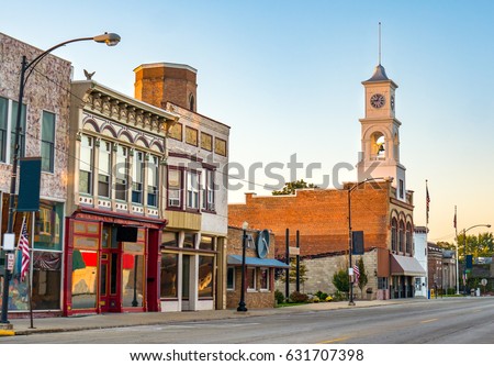Main street of a quaint, classic small town in midwest America with storefronts and a clock tower