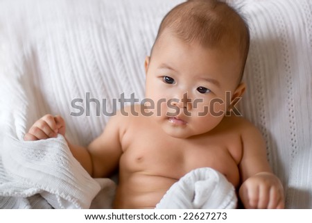 Baby lying in bed under a blanket