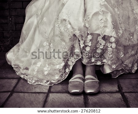 Young woman in beautiful wedding gown made with pineapple fiber. Casual sporty shoes are being worn on her feet. Vintage processing.