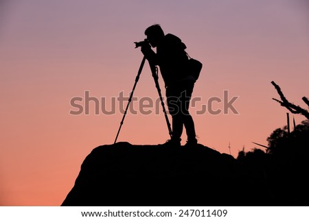 Silhouette of a photographer who shooting a sunset on the mountains