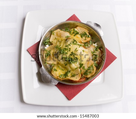 sturgeon roasted under potatoes and cheese