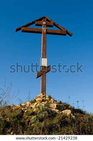 Cross on the hill behind blue sky