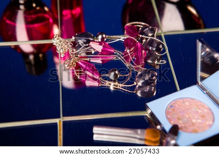 Purple bijouterie in cosmetics stuff on mirrors