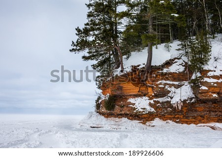 Rocky cliff / shoreline on frozen Lake Superior.  Highly textured rock.  Copy space to the left.  Apostle Island National Lakeshore on Lake Superior in Wisconsin, a popular winter travel destination.