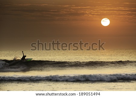 Surfer making a perfect turn in a beautiful sunset in northern Peru, South America.