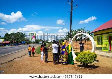 Kampala area, Uganda - October 15th 2015 - A family takes pictures in the Equator line mark separating the north and south hemisphere in Uganda, East Africa.
