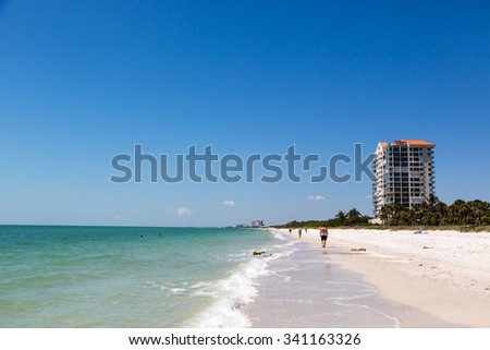 Naples, Florida - May 18th 2014 - Beautiful blue sky day in the beach of Naples in Florida with some buildings in the background. USA