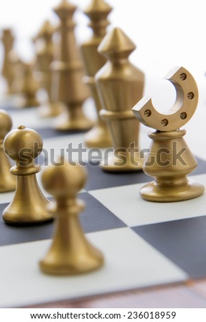 Classic chess game - gold playing pieces lined up on chessboard