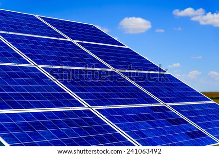 ground solar panels in a field under a blue sky