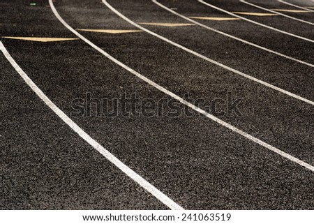 outdoor black running track with painted lane lines