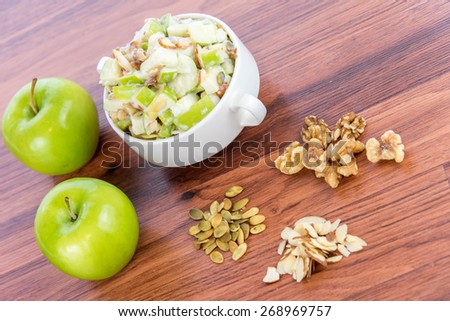 healthy snack: apple salad with almonds, walnuts and pumpkin seeds, condensed milk and lemon juice