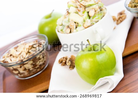 healthy snack: apple salad with almonds, walnuts and pumpkin seeds, condensed milk and lemon juice
