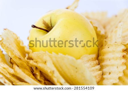 yellow apple vs yellow salty potato chips - snack decision between healthy food or junk food