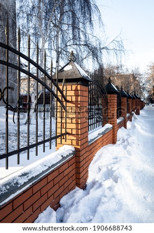 metal fence on brick pillars on a winter sunny day