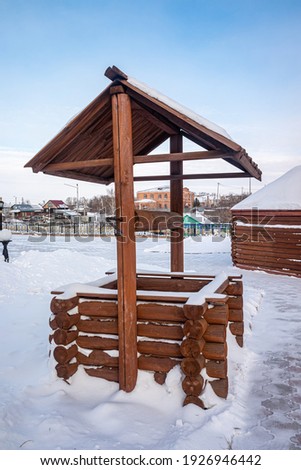wooden well in the snow in winter