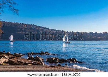 view over Burrard Inlet, ocean and island with boat and mountains in beautiful British Columbia. Canada.