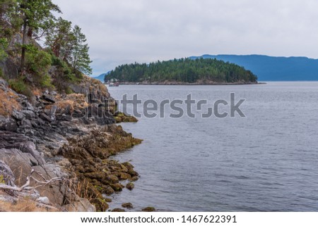 View over Burrard Inlet, ocean and island with boat and mountains in beautiful British Columbia. Canada.