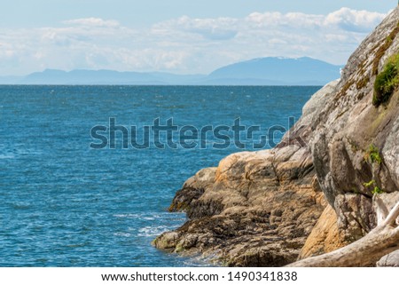 View over Burrard Inlet, ocean and island with boat and mountains in beautiful British Columbia. Canada.