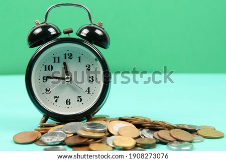 alarm clock along with coins to remind you to save money