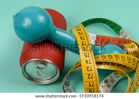 Red aluminum drink can with colorful measuring tape symbolizing person wanting to lose weight\
G