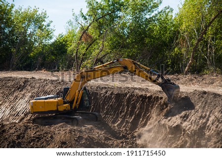 The driver uses the bucket of the excavator to perform earthworks