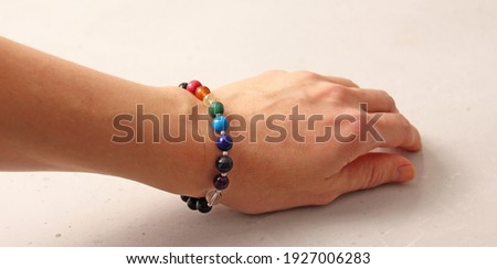 Colorful bright bracelet. Bracelet made of stones on hand from natural stone Colorful bright. Bracelet made of natural stones. Handmade jewelry. Handmade bracelets on light modern background.