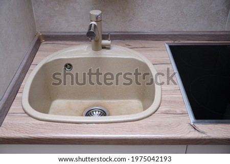 Beige clean kitchen sink with faucet for drinking water