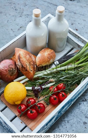 wooden box with fresh produce, fresh bread and olive oil