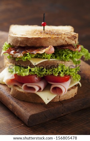 close up of fresh sandwich with ham, bacon,tomatoes,cheese and lettuce