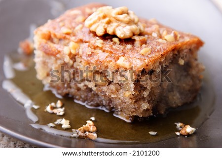 closeup of walnut cake with honey or sirup, focus on the cake texture in front