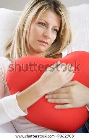 young female dreaming with a big love heart in her hands