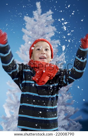 little boy having a great time in the snow (studio shot)