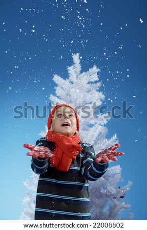 little boy throwing snow in the air